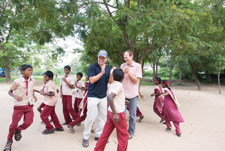Gary White and Matt Damon play with schoolchildren in Tiruchirappalli, Tamil Nadu, India